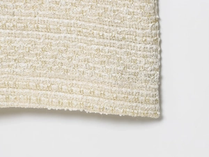 Vue macro de la texture du tissu tweed beige et doré avec fils métalliques brillants