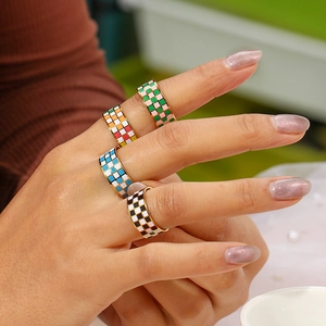 Close-up of 18K gold plated checkerboard enamel rings in pink, blue and black patterns