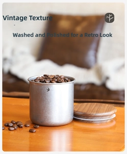 Detailed macro view of vintage stainless steel canister with bird logo and wooden lid