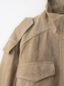 Detailed macro view of khaki suede jacket shoulder strap and fine stitching texture
