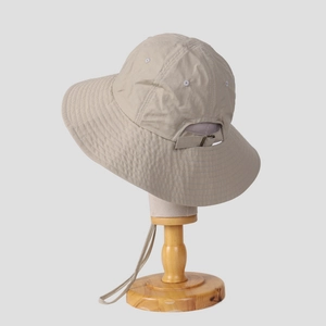 Detail of breathable hiking hat featuring adjustable buckle and chin strap in light beige