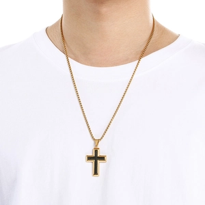 Dettaglio di un modello maschile con collana a croce bicolore in oro e acciaio inossidabile