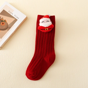 Detail view of red knitted Christmas stocking socks featuring a plush Santa Claus figure