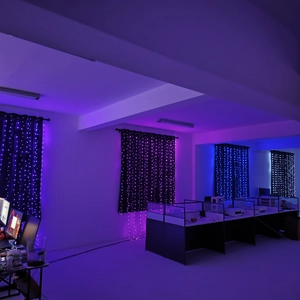 Detail of blue and purple LED curtain string lights hanging in a home office setting