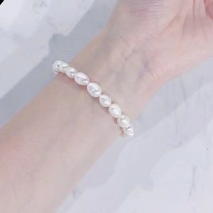 Close-up of natural baroque freshwater pearl bracelet on a woman's wrist with marble background