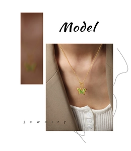 Gros plan détaillé d'un collier pendentif papillon doré avec émail vert sur un mannequin