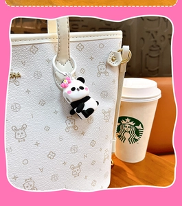 Vista dettagliata di un simpatico ciondolo per borsa panda con un piccolo fiore rosa