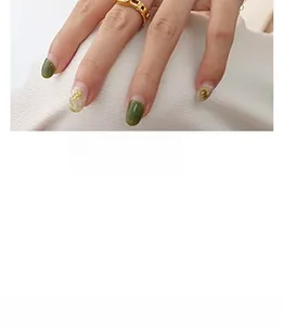 Detail of hollow geometric gold ring on index finger with matching designer nail art