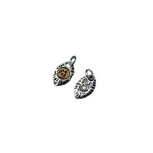 Macro shot of Tibetan style leaf shaped alloy pendants with intricate engraved eye patterns