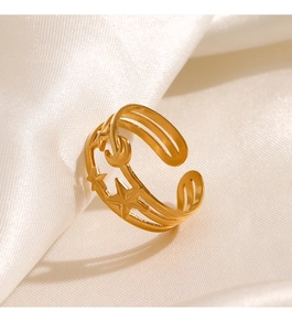 Close-up of golden celestial star and moon ring on elegant white satin fabric