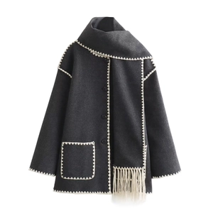 Detail showing deep gray wool coat with white scalloped stitching and fringed scarf end