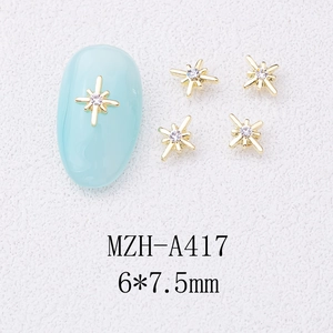 Close-up of gold alloy star nail charms with crystal rhinestones sized 6x7.5mm