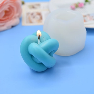 Creative blue knot scented candle and silicone mold on a soft blue decorative background