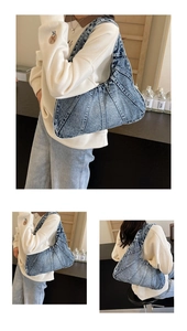 Détail du sac à bandoulière en denim bleu avec design plissé et texture délavée