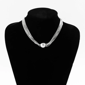 Detail of silver layered chain necklace with a metallic sphere bead on a black bust