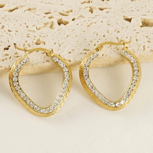 Close-up of gold titanium steel heart earrings with rhinestones and Greek key pattern