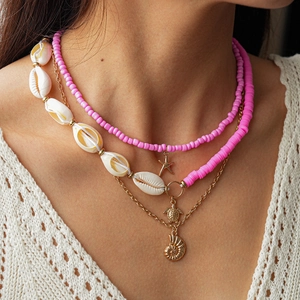 Detail view of multi-layer necklace with pink beads, sea turtle charms and starfish pendant