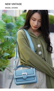 Detail of light blue crossbody bag with contrast stitching and floral pattern strap