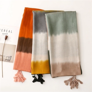 Detailed view of color-blocked gradient scarf with tassels and woven texture