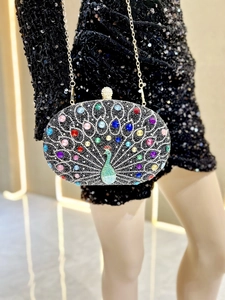 Detailed shot of peacock rhinestone evening bag with colorful crystals and gold chain strap