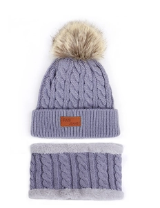 Detailed knit pattern on purple winter hat and scarf set with soft faux fur trim