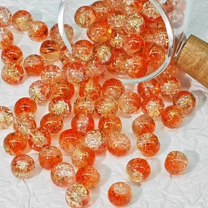 Macro shot of 10mm orange brushed glass beads with gold foil and crackle detail