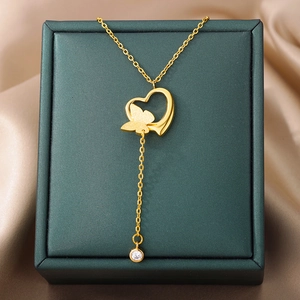 Detail of 18k gold butterfly heart pendant with zircon on green velvet gift box