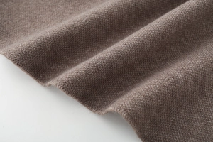 Macro detail of the soft brown knit fabric showing elegant drape and premium texture