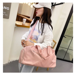 Model wearing a pink large capacity travel bag with adjustable strap in a cafe setting
