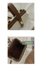 Detail view of contrast color handbag with gold metal clasp showing interior storage capacity