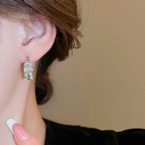 Detailed macro shot of marquise-cut zircon wheat ear earrings worn on a model's ear