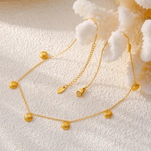 Collana in acciaio inossidabile dorato con ciondolo a conchiglia su corallo bianco