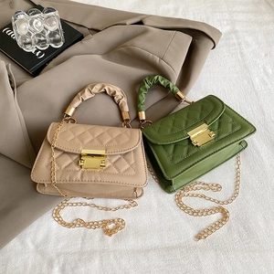 Detalle de bolsos acolchados beige y verde con cadenas y asas rizadas