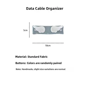 Detail of fabric cable organizer with star pattern and white plush wing accents