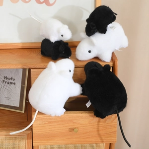 Detalle de adorables peluches de ratón en blanco y negro sobre un mueble de madera