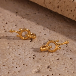 Macro shot of 18K gold plated lava-style fluid design earrings on a natural stone base