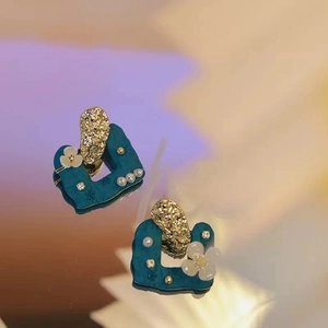 Peacock blue geometric earrings with gold flower, pearl details and mirror reflection