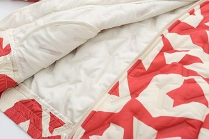 Détail de la doublure blanche respirante et du motif géométrique rouge sur la doudoune