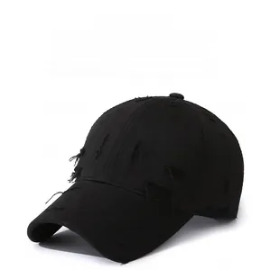 Close-up of black distressed baseball cap featuring vintage frayed edges and side embroidery