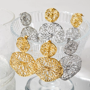 Modern double circle filigree earrings in gold and silver finish on glass backdrop