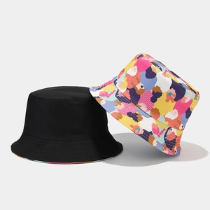 Dettaglio del cappello a secchiello reversibile con lato nero e motivo graffiti colorati