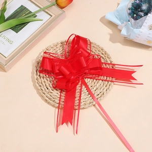 Dettaglio di fiocco rosso in organza su tappetino intrecciato per decorazione regali