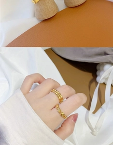 Detail of 18K gold-plated bow and bamboo style rings stacked on woman's fingers