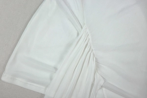 Macro detail of white knitted fabric showing fine texture and side drawstring ruching