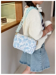 Detail of floral lace crossbody bag with 3D blossoms and blue tulle shoulder strap