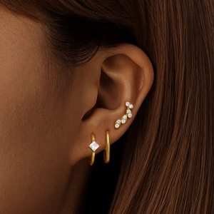 Close-up of S925 silver gold earrings set with white zircon stones on a female model