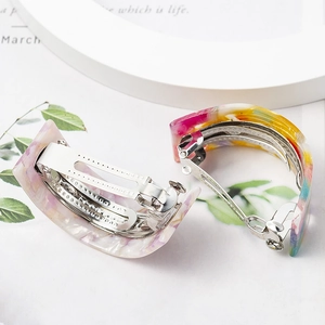Close-up of pearlized lavender and multicolor marbled resin U-shaped hair clips
