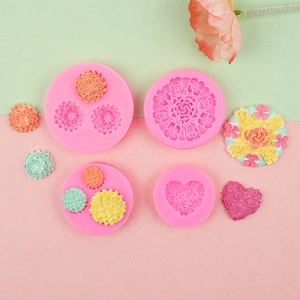 Detailed view of pink silicone flower and heart molds for fondant cake decoration