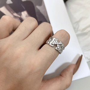 Minimalist wide silver ring with textured surface and X-shaped zircon star inlay