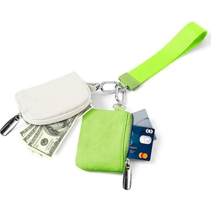 Detailed view of cream and neon green wristlet pouches with cards and cash inside